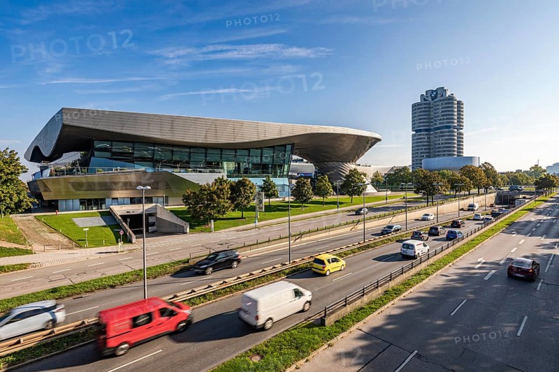 Road traffic in front of BMW Welt and the BMW four-cylinder administration building in Munich, Bavaria, Germany, Europe