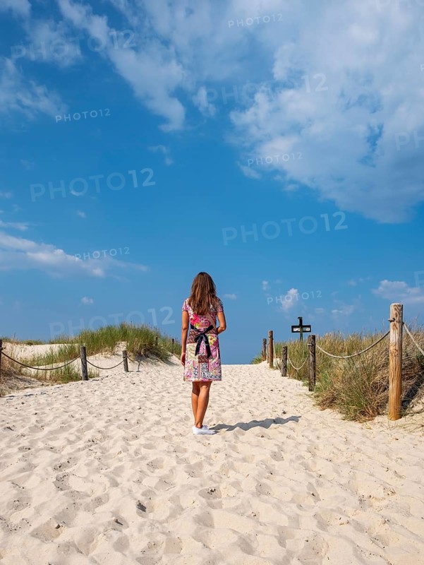 Woman in colourful dress on empty beach, Slovincian National Park, Slowinski Park Narodowy, Poland, Europe