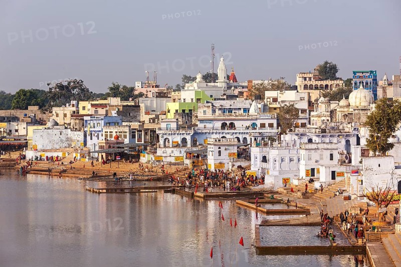 PUSHKAR, INDIA, NOVEMBER 20, 2012: Hindu devotees pilgrims bathing in sacred Puskhar lake (Sagar) on ghats of Pushkar, Rajasthan, India. Pushkar is holy city for Hinduists and famous for many Hindu temples
