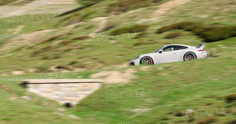 Speed effect photo of sports car Porsche GT3 driving on mountain road in Hocchalpen, Auvergne-Rhône-Alpes department, France, Europe