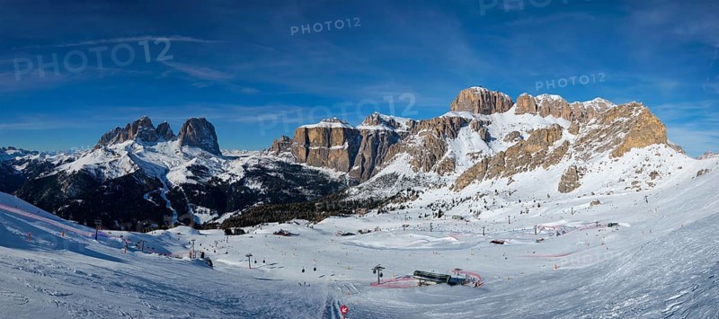 Panorama of a ski resort piste with people skiing in Dolomites in Italy. Ski area Belvedere. Canazei, Italy, Europe