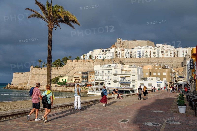 Tourists on the promenade, in the background the old town, Peñíscola, province Castellón, Costa del Azahar, region Valencia, Spain, Europe