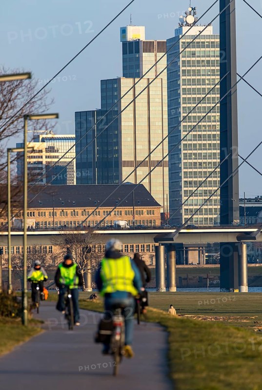 Düsseldorf, city centre skyline, skyscrapers, Rheinkniebrücke, Rhine, cyclists on the Rhine embankment path in Düsseldorf Oberkassel