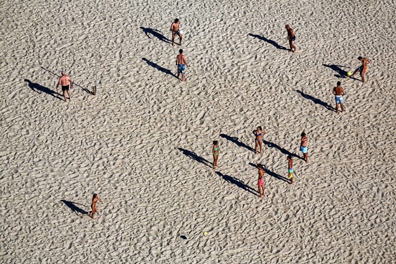 Beach volleyball on the beach of Nazaré, players cast long shadows, view from above, Portugal, Europe