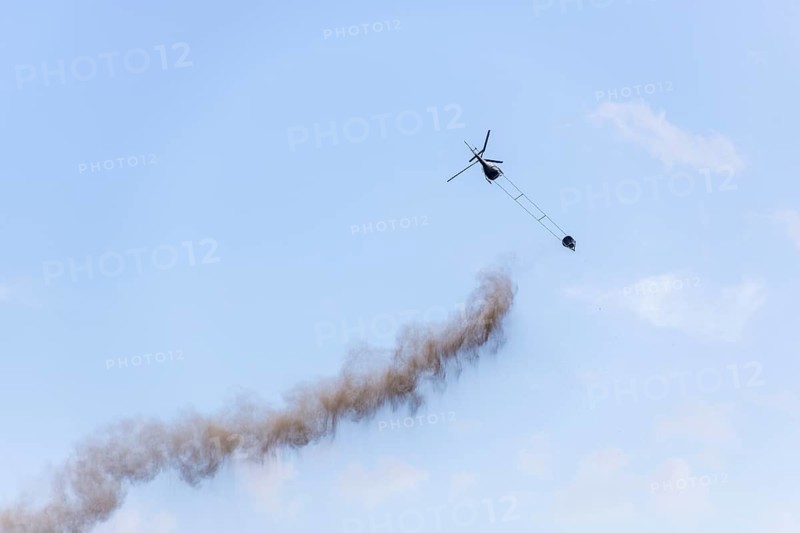 Symbolic image, climate change, helicopter, helicopter spreading finely painted limestone and ash against acid rain, container, soil protection liming, forest liming, Baden-Württemberg, Germany, Europe
