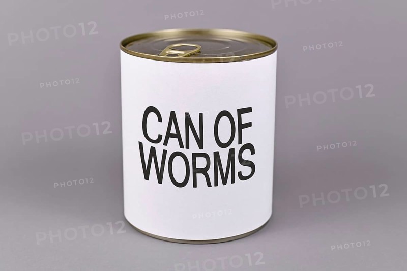 Concept for difficult situations and unpleasant experiences showing a tin can with white label and words Can of worms on gray background