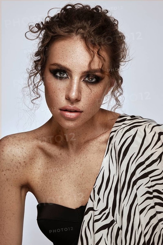 Beautiful girl with an unusual hairstyle and creative makeup. Beauty face. Photo taken in the studio