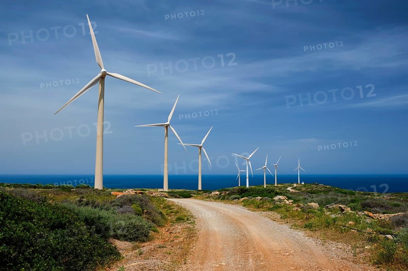 Green renewable alternative energy concept, wind generator turbines generating electricity. Wind farm on Crete island, Greece with road