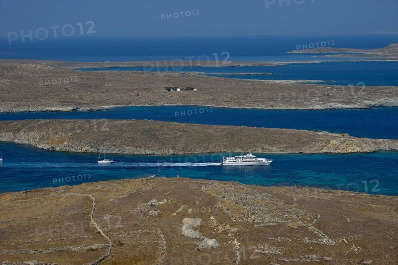 View over the island of Delos with an excursion boat, Cyclades, Greece, Europe