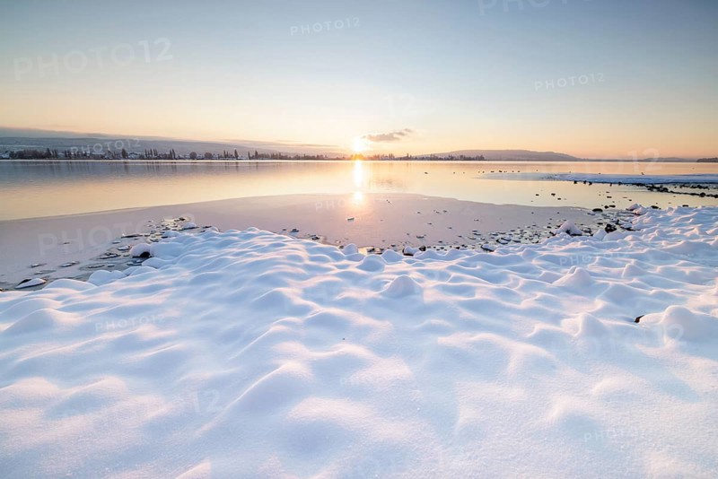 Snow-covered lakeshore in the peaceful atmosphere of a winter sunset, Seegarten, Allensbach, Lake Constance, Baden-Württemberg, Germany, Europe