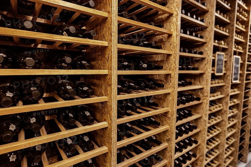 Bottles with wine stacked on wooden racks