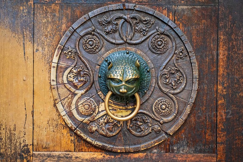 Old brass door knocker on wooden door