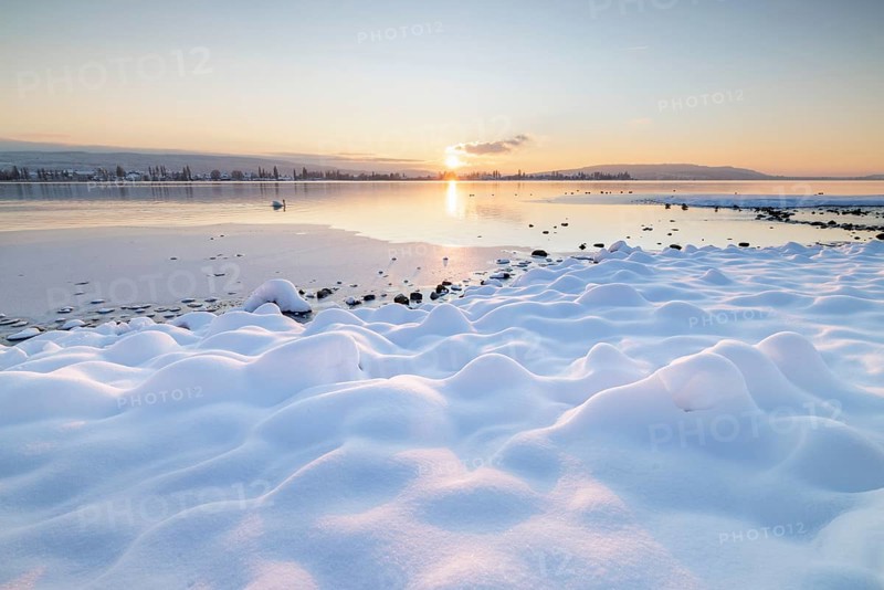 The wintery snow-covered lake with setting sun and peaceful atmosphere, Seegarten, Allensbach, Lake Constance, Baden-Württemberg, Germany, Europe