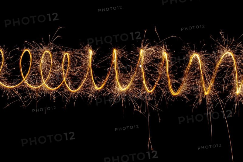 Spiral lights with sparks on a black background. Christmas lights on a long exposure