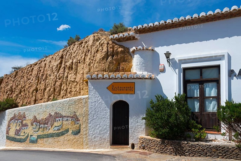 Small restaurant in a white building with painted walls and rustic charm under a blue sky, Pedro Antonio de Alarcon cave hotel, Guadix, Granada province, Andalusia, Spain, Europe