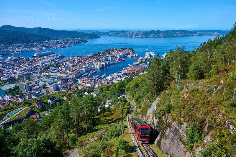 Panoramic view of Bergen with harbour on a clear day, cable car ascending the wooded mountain, Fløibanen mountain station, Bergen, Vestland, Norway, Europe