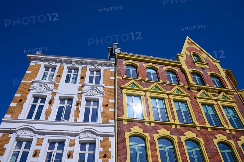 A historic building with an elaborate façade and many windows, surrounded by a clear blue sky, Bergen, Vestland, Norway, Europe