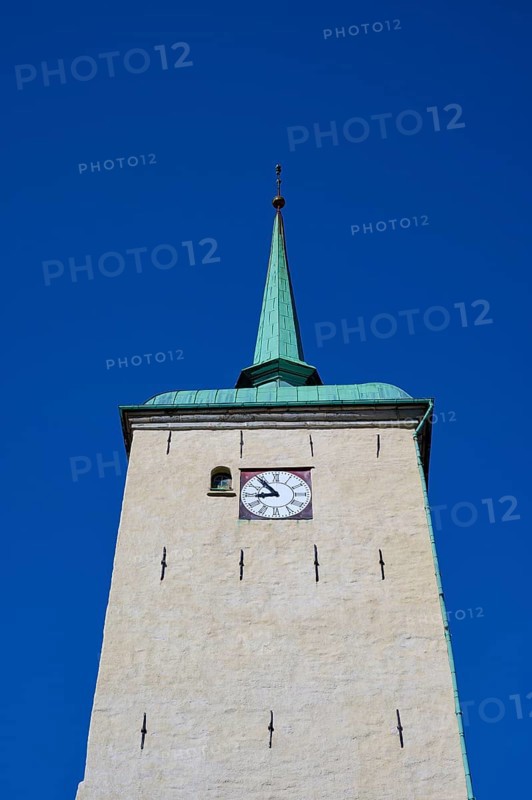 Historic church tower with green copper spire and built-in clock in front of a clear blue sky, Bergen, Vestland, Norway, Europe
