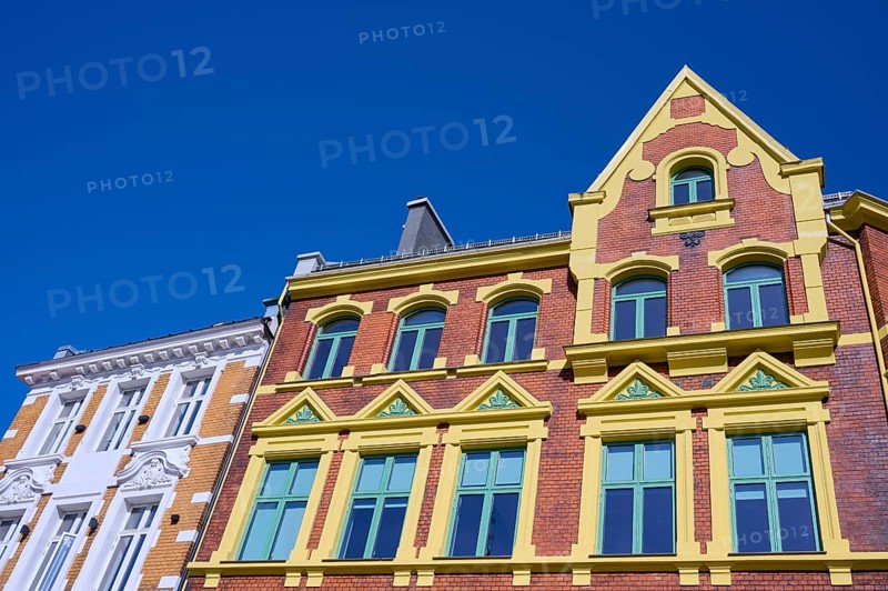 A historic building with an elaborate façade and many windows, surrounded by a clear blue sky, Bergen, Vestland, Norway, Europe