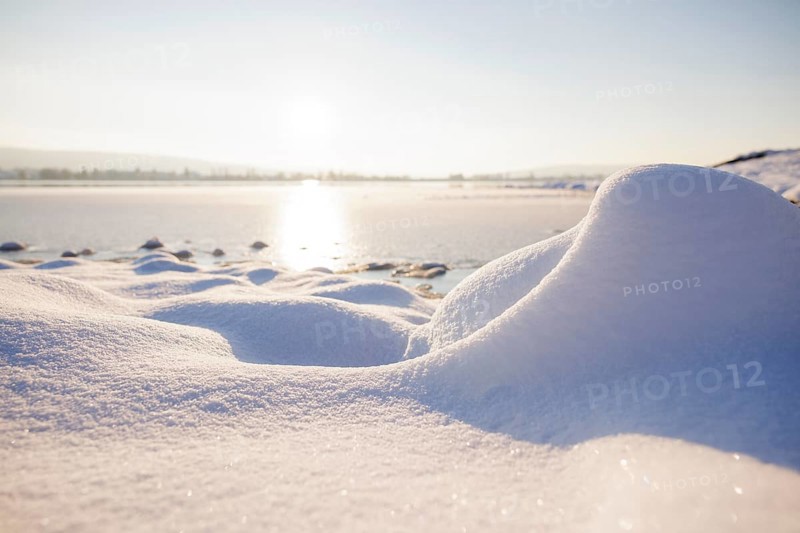 Snow covers the ground as the sun sets over a wintry lake, Seegarten, Allensbach, Lake Constance, Baden-Württemberg, Germany, Europe