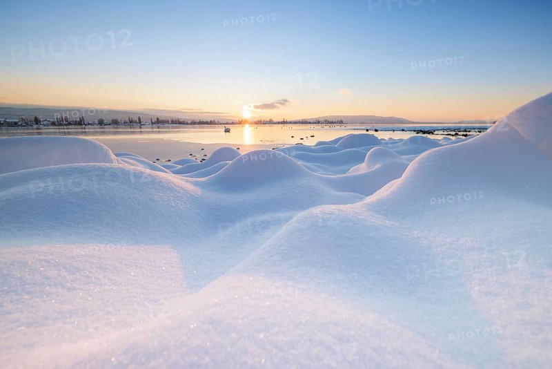 Winter snowy landscape with a lake at sunrise and some clouds, Seegarten, Allensbach, Lake Constance, Baden-Württemberg, Germany, Europe