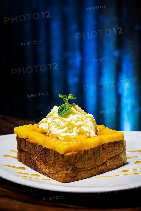 Exotic tropical fusion french toast dessert with mango and whipped cream