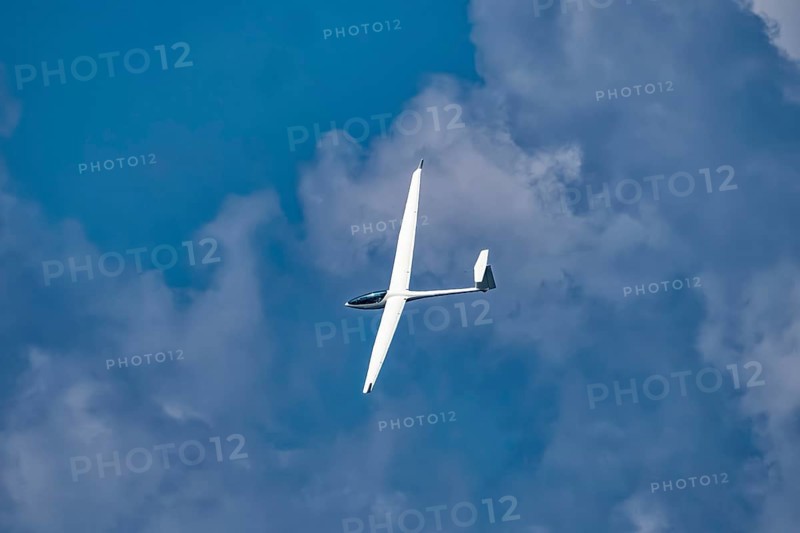 Glider plane flying in the clouds