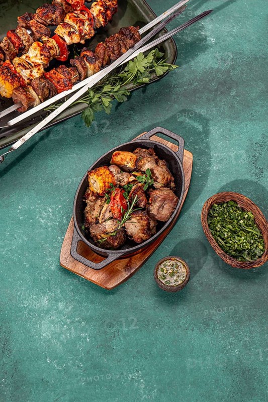 Food, Bbq grilled meat, pork, chicken and vegetable on cast iron pan. Grilled skewers on yellow wooden background. Top view