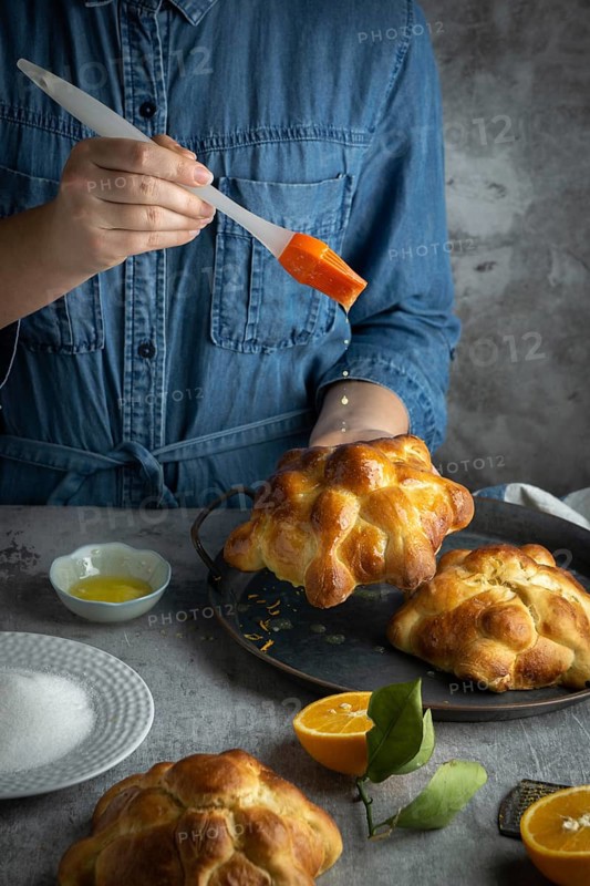 Food Photography, Woman preparing Pan de muertos bread of the dead for Mexican day of the dead