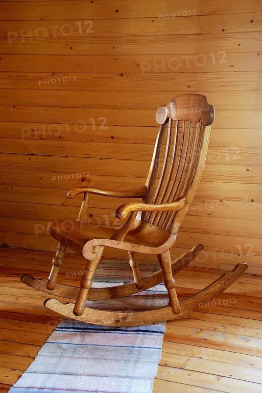 Carved wooden rocking-chair in the country-style interior