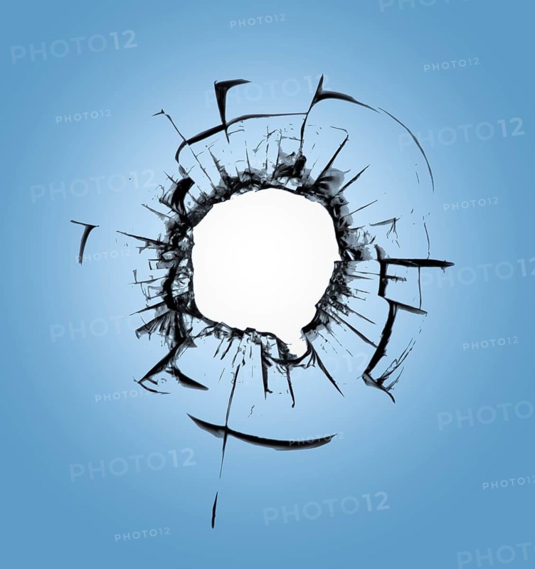 Bullet holes in the window against the blue sky. Consequences of shelling and cracks on the glass