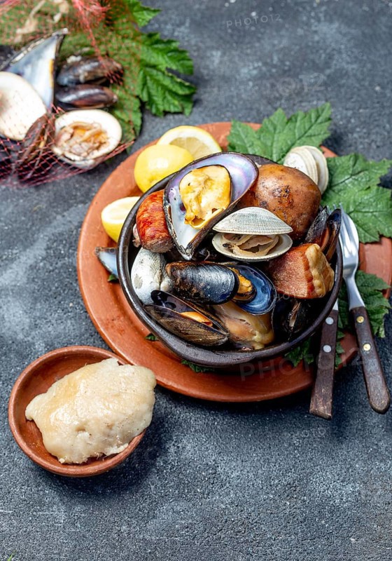 Famous traditional dish of the south of Chile and the Chiloe archipelago, Curanto Kuranto. Different seafood and meat cooked in a pit on the coals under the ground