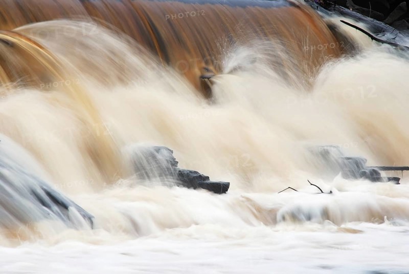 Waterfall, foaming and splashing waves of a river