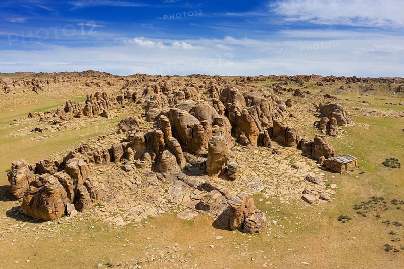 Aerial view at rock formations and stacked stones on granite hilltops. Baga Gazriin Chuluu, Gobi desert, Mongolia, Asia
