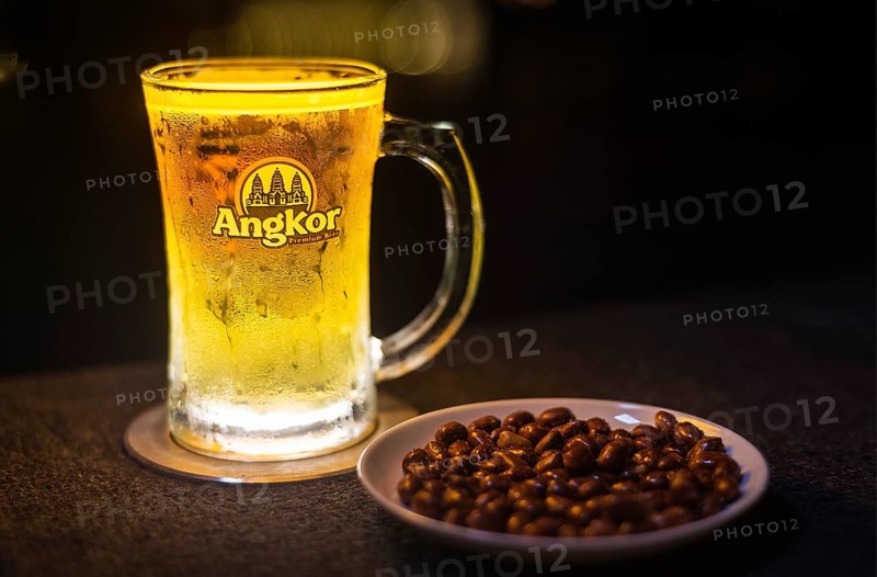 Glass of popular cambodian angkor beer draft with peanuts in bar
