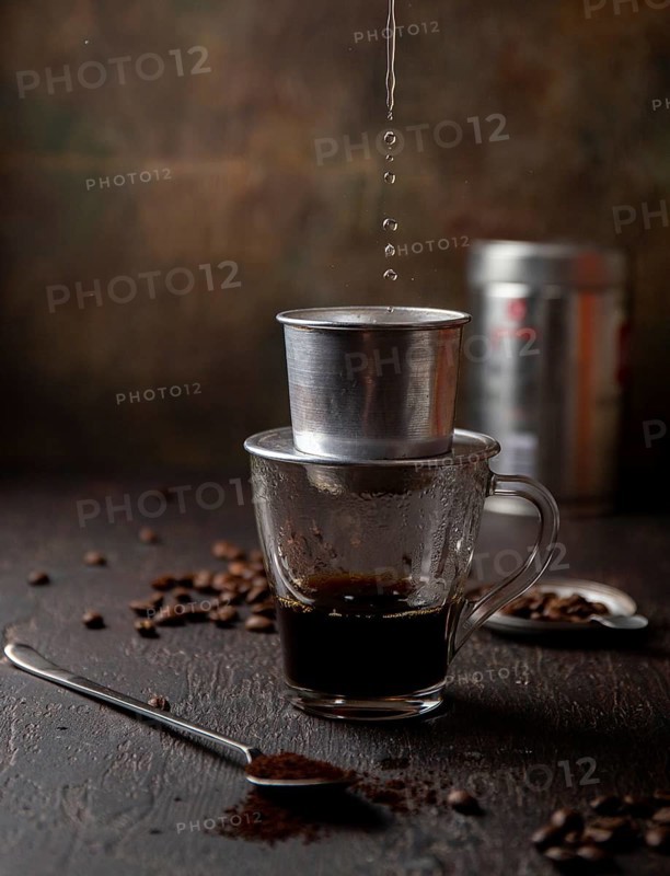 Preparation of Vietnamese coffe with aluminum cofe filer on dark background