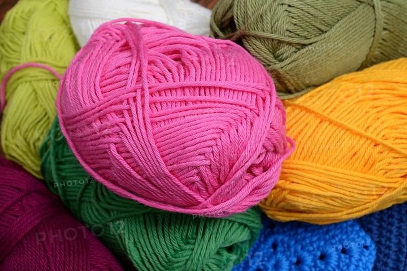 Colorful skeins of wool, pink yellow and green