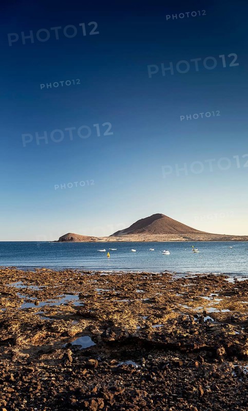 Rocky coast landscape with montana roja mountain near el medano in south tenerife island spain