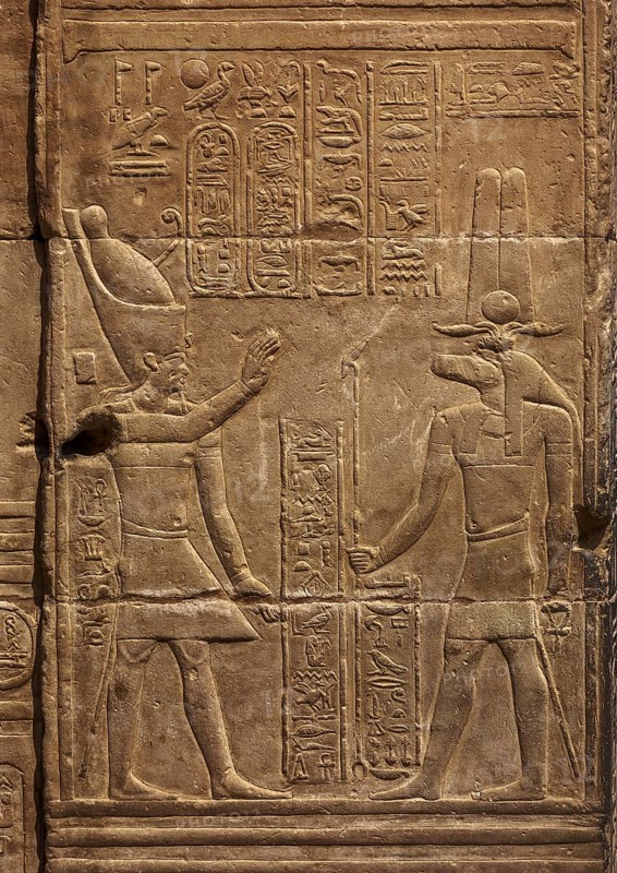 Hieroglyphic carvings of Sebek god and pharaoh on the walls of an ancient egyptian temple