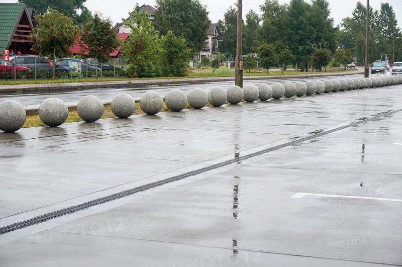 Stone balls as a design course in the landscape of the city, wet road, rainy day