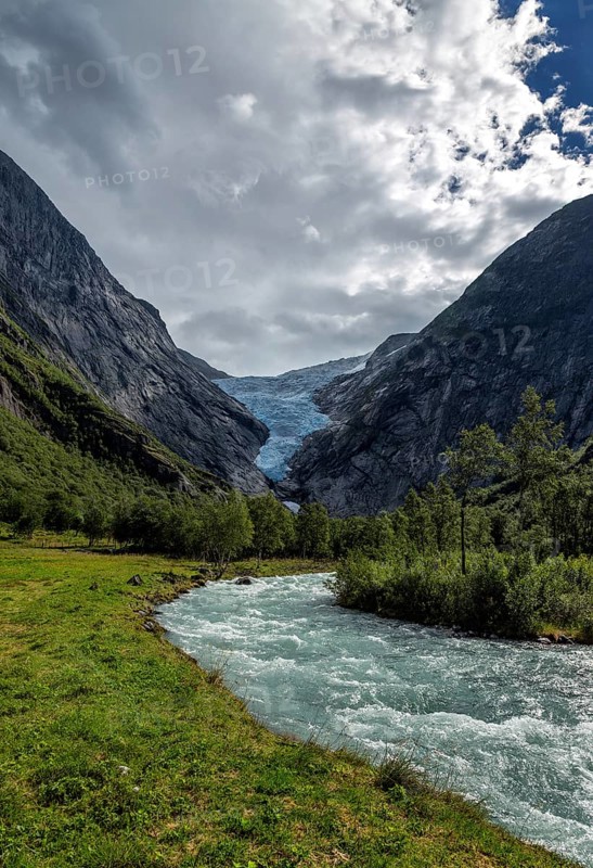 Panoramic view of the Briksdalsbreen glacier with meltwater flow in the foreground