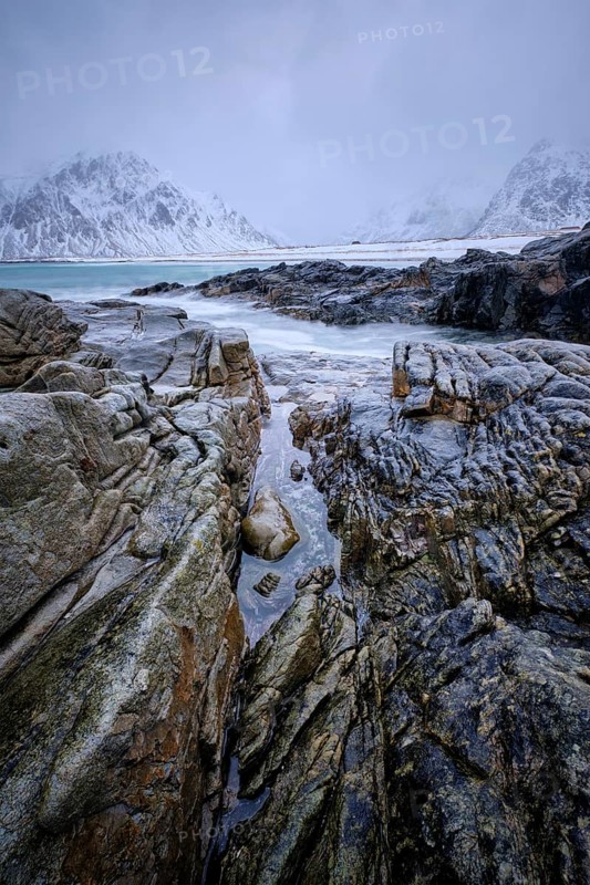 Waves and rocks on coast of Norwegian sea in fjord. Skagsanden beach, Flakstad, Lofoten islands, Norway. Long exposure motion blur