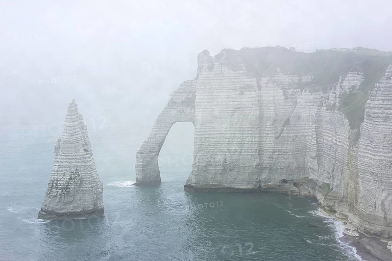 L'Aiguille and the Porte D'Aval, a natural arch in the chalk cliffs at Etretat in the mist, Côte d'Albâtre, Upper Normandy, France, Europe