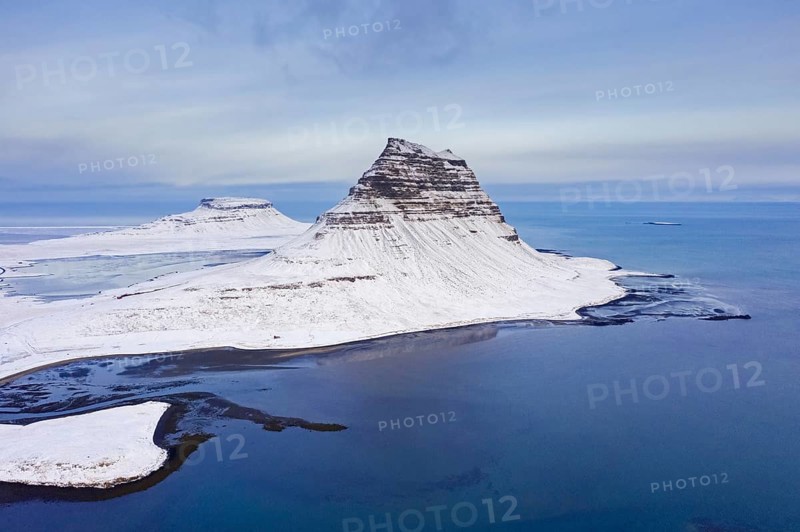Aerial view over Kirkjufell, nunatak hill covered in snow on the Snæfellsnes peninsula in winter, most photographed mountain in Iceland