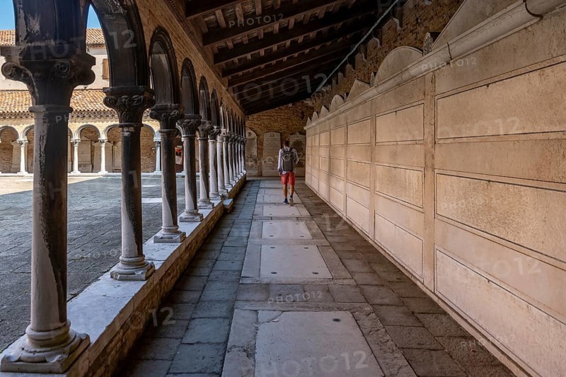 Young man in the cloister with graves, church Chiesa di San Michele in Isola, cemetery island San Michele, Venice, Italy, Europe