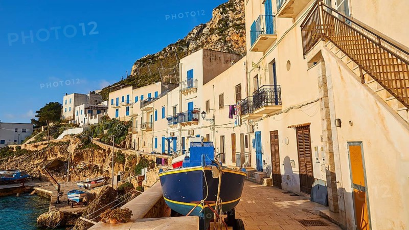Morning light, row of houses, colourful houses, boat, Levanzo town, main town, Levanzo, Egadi Islands, Sicily, Italy, Europe