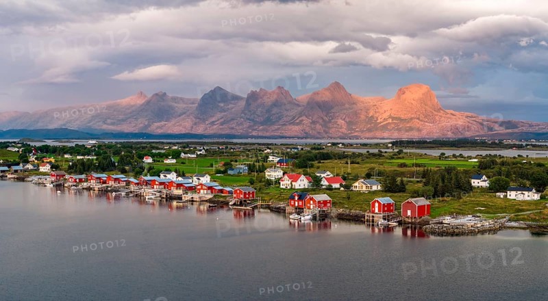 Boathouses of the village Herøy, behind the mountain range Seven Sisters, light mood, island Herøy, Helgeland coast, Nordland, Norway, Europe