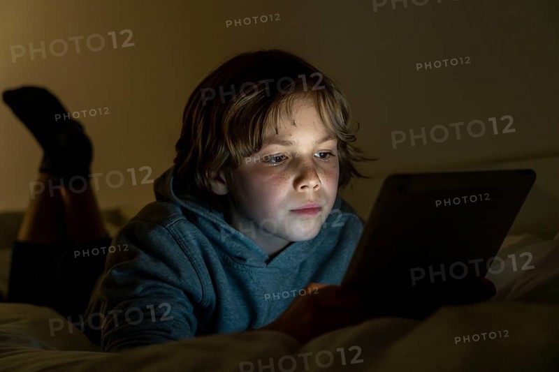 A boy plays computer games on a tablet PC