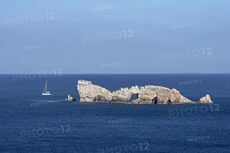Sailing boat passing the Rocher du Lion, rock with natural arch seen from the Pointe de Pen Hir, Crozon Peninsula, Finistère, Brittany, France, Europe