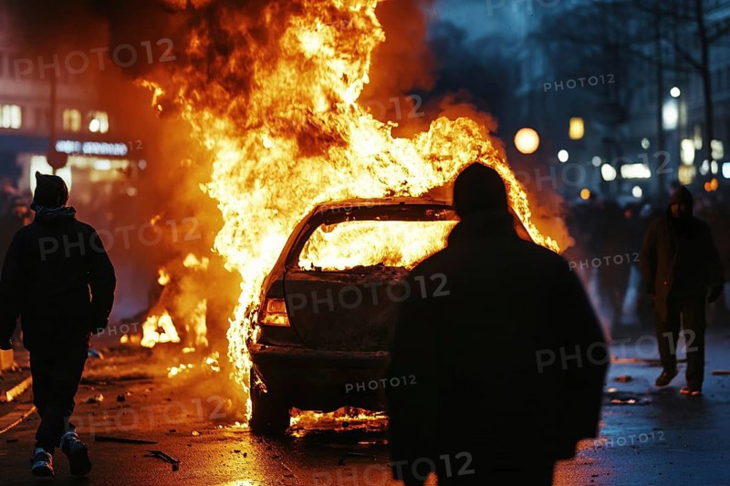Burning car in street with rioting people at night. Generative Ai, AI generated